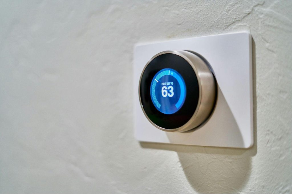 Wall-mounted smart thermostat with a sleek circular display, highlighting how smart home technology integrates into modern interiors